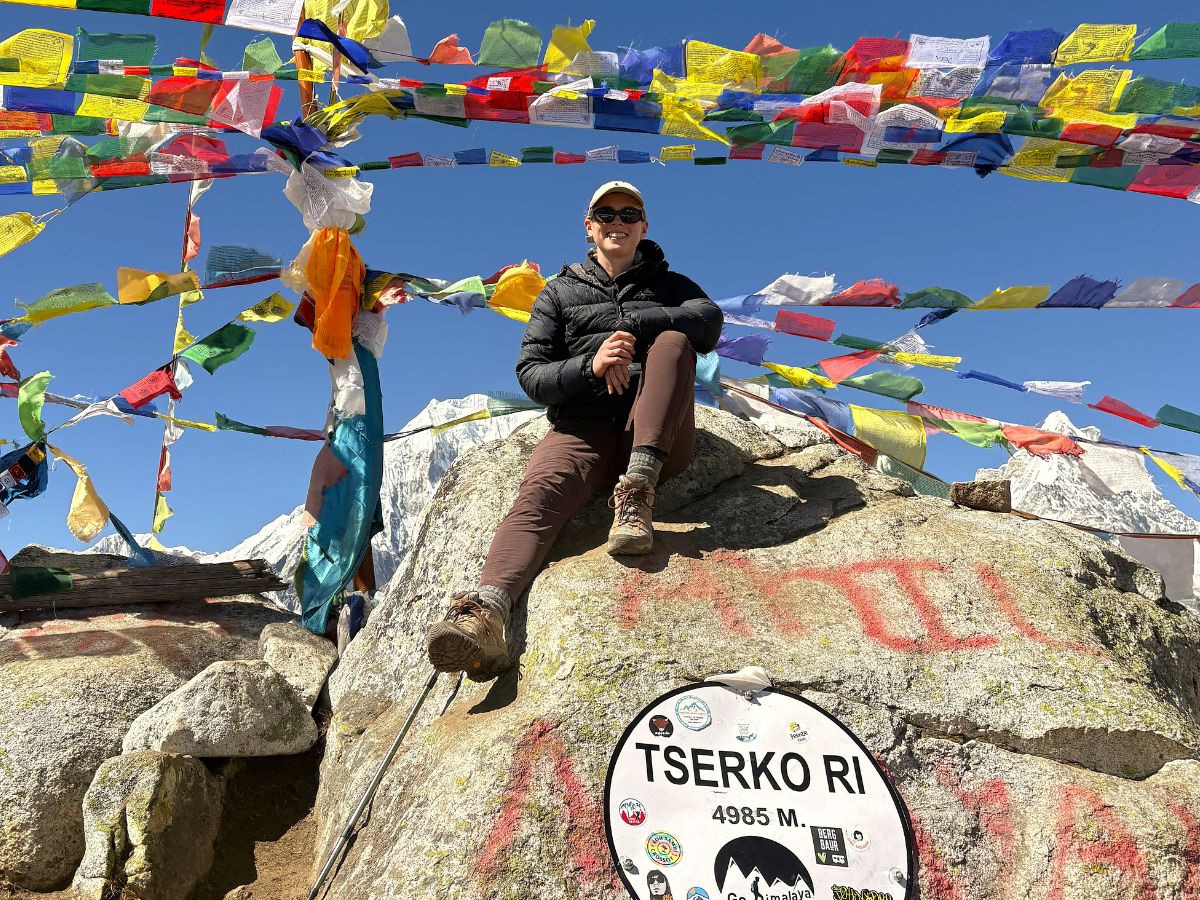 Trekker at Tserko Ri summit overlooking the mountain range.